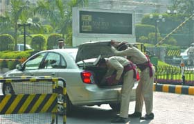 Hotel securitymen check a car in New Delhi