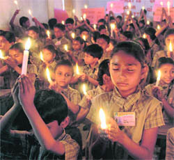 Students light candles to protest against Mumbai terror attacks in Ahmedabad on Thursday. 