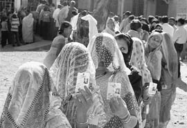 Women line up to cast their vote at a polling booth during the state assembly elections in Bhopal on Thursday.