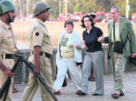 An employee of Taj Hotel (centre) comforts foreign guests in Mumbai on Thursday.