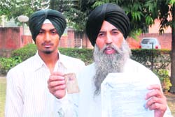 Amandeep Singh with his father Gurcharan Singh, who has allegedly been implicated in a false case, in Jalandhar on Thursday. 