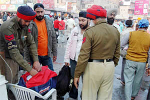 Cops check luggage of visitors near the Golden Temple on Friday.