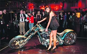 A model poses with a motorcycle named 'JFK' during a press presentation prior to the Essen Motor Show in Essen
