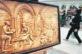 A woman walks past a relief carved from chocolate at the Salon Du Chocolate food fair in Moscow