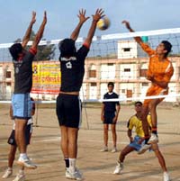 Players of DAV College, Bathinda, and village Kot Sameer, vying for the ball in the District Volleyball Championship at the MGDAV College in Bathinda 