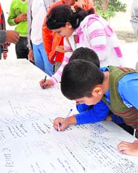 DRIVE AGAINST TERRORISM: Children write their views on global terrorism along with others at a programme organised by students of MM Engineering College, Mullana, in Ambala district