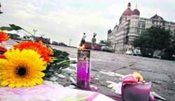 A TRIBUTE: Candles and flowers placed in front of the Taj in Mumbai.