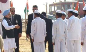 NSG officers and Congress workers look on as Prime Minister Manmohan Singh arrives to address an election rally in Hanumangarh, Rajasthan, on Monday