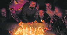 Members of The Voice, a social welfare and human rights organisation, light candles on World AIDS Day in Shimla on Monday.