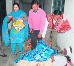 Members of the local Lions Club give a blanket to a beggar in Ambala.