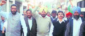 MLA Sandhu Singh Dharamsot along with others raise slogans against the government in Amloh on Monday.