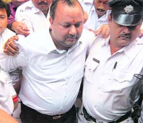 Police escort Ashok Todi after he surrendered at a city court in connection with the Rizwanur Rehman murder case in Kolkata