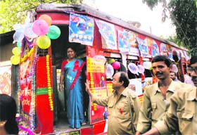Tram drivers (right) greet an activist standing inside a tram car decorated with posters, flowers and condoms to raise awareness about HIV/AIDS on World AIDS Day in Kolkata