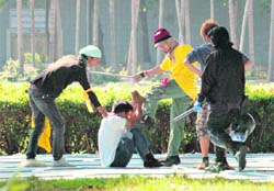 An anti-government demonstrator kicks a suspected pro-government supporter after detaining him in Bangkok's Suvarnabhumi Airport