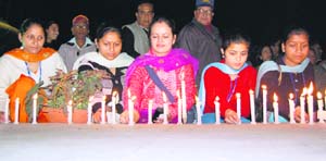 Students of INC, Dharamsala, pay homage to those killed in terror attacks in Mumbai by lighting candles at Dharamsala 