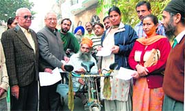 Deputy speaker, Satpal Gosain, gives cheque to a disabled in Ludhiana on Tuesday.