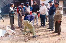 Officials of the vigilance department and Punjab Engineering College, Chandigarh, collect samples from a road in Ludhiana on Tuesday. 