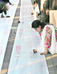 People sign messages of condolence on a banner outside the Trident hotel in Mumbai on Tuesday.