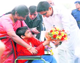 Deepinder Hooda, MP, presents flowers to a child on World Disability Day in Gurgaon