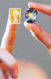 A Christies auction house employee shows the Wittelsbach Diamond (R) and a stamp during a press view in London on Friday. The 17th century 35.56 carat jewel was selected by King Philip IV of Spain as a part of a dowry for his daughter Infanta Margarita Teresa's engagement to Leopold I of Austria in 1664. The diamond, valued at around 9 million GBP, (10.3m euros/$13.1m) will be auctioned in London on December 10 as a part of an auction entitled 'Jewels: The London Sale.'