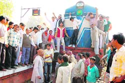 Protesting traders block the 2RF Rewari-Fazilka passenger train at Sirsa on Friday. 