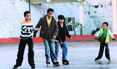 Children enjoying ice skating in the rink hall in Shimla 