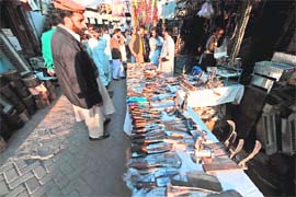 SHARP SKILLS: A man looks at knives on sale for the forthcoming Eid-al-Adha celebrations at a market in Islamabad on Friday.