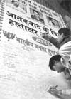 People sign a poster during the BJYMs signature campaign in Ludhiana on Saturday. 