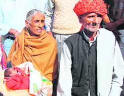 Rajjo Devi holds the baby girl she delivered at the age of 70 alongside her husband Bala Ram (72) in Hisar. 