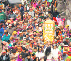 People carry deities in decorated palanquin after taking a holy dip at Vashisht village, near Manali, on Sunday.