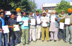 People show the documents given by the travel agents, in Nawanshahr. 