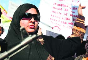 Muslims hold placards and flags during a protest rally against the recent terrorist attack in Mumbai
