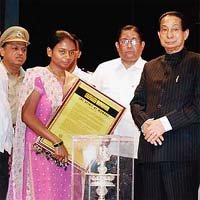 Maharashtra Governor S.C. Jamir felicitates daughter of martyr assistant sub-inspector Tukaram Omble for his courage during the Mumbai terror attack, in Mumbai