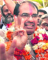 Madhya Pradesh Chief Minister Shivraj Singh Chouhan flashes a victory sign after partys win