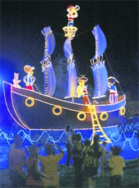 People look at an illuminated boat in Cartagena, Colombia