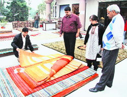 Visitors have a look at the carpets displayed during the exhibition organised at Sutlej Club. 