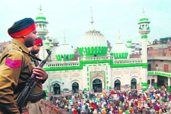 Muslims perform namaz while security guards keep a close watch at the Khairudin mosque in Amritsar on Tuesday. 
