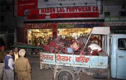 Municipal Corporation officials seize the chairs and the tents, which a shoe store owner had pitched on the Goniana road in Bathinda