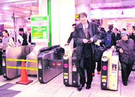 Commuters walk on a piezoelectric sheet, which generates electricity when pedestrians step on it at the Tokyo station