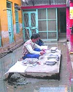 Employees sort the post amid filthy water accumulated in the present post office bulding in Nawanshahr