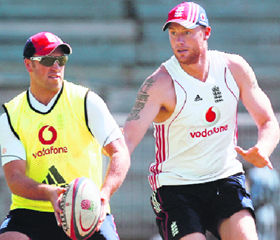 England's Andrew Flintoff (R) and Matt Prior play with a rugby ball during a practice session.