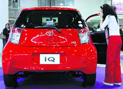 A woman looks at a Toyota Motor Corps IQ car at a showroom in Tokyo on Thursday.