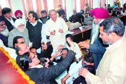 Congress municipal councillors sit on a dharna in front of the mayors table during the municipal house meeting in Ludhiana