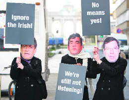 People wearing masks depicting Frances President Nicolas Sarkozy (left), Britains Prime Minister Gordon Brown (centre) and his Irish counterpart Brian Cowen, take part in a protest against European Union leaders plans to ignore the Irish no vote outside the European council headquarters in Brussels on Thursday.