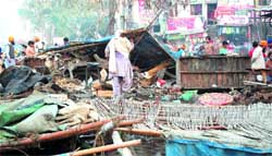 People carry their belongings after the MC squad demolished the encroachments in the Chheharta area in Amritsar