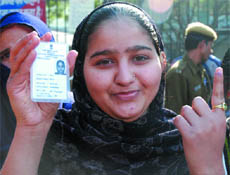 A woman shows her voter I-card after casting her vote at Dasghara in New Delhi on Saturday.