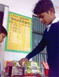 A student putting cash in a box provided at the Imandaari ki dukan at the government school in Multania village. 