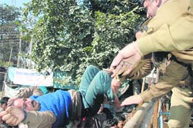 A shiksha mitra falls after trying to scale a barricade