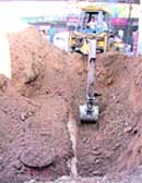 JCB machine being used to dig the earth for removing a tank of a petrol station