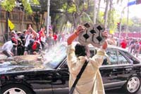 Protesters attack a car coming out of Parliament with rocks after the voting for the countrys Prime Minister in Bangkok on Monday.  AP/PTI